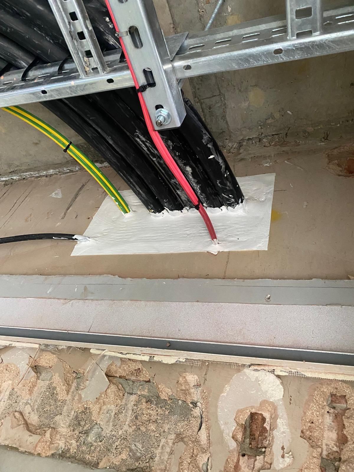 A bunch of wires are hanging from the ceiling of a building.