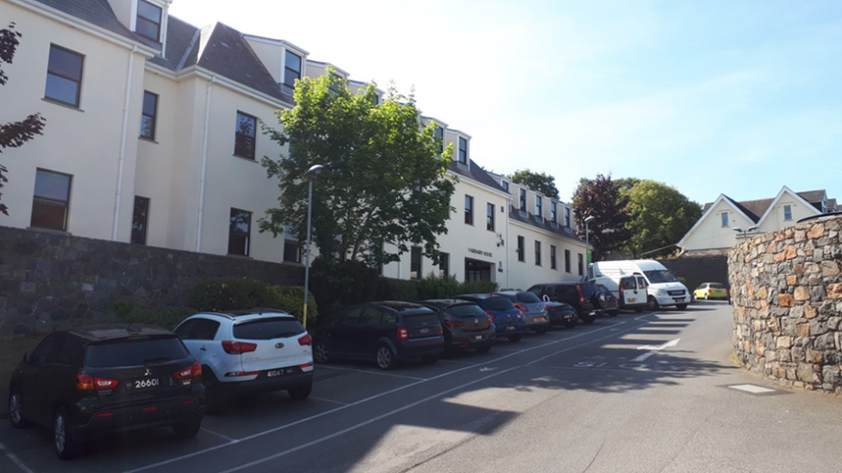 Three-story brick building on a street corner, with storefronts below and 