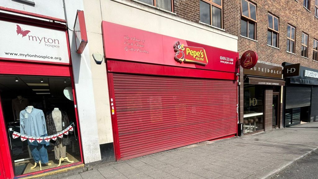 A brick building with a red awning on the side of it.