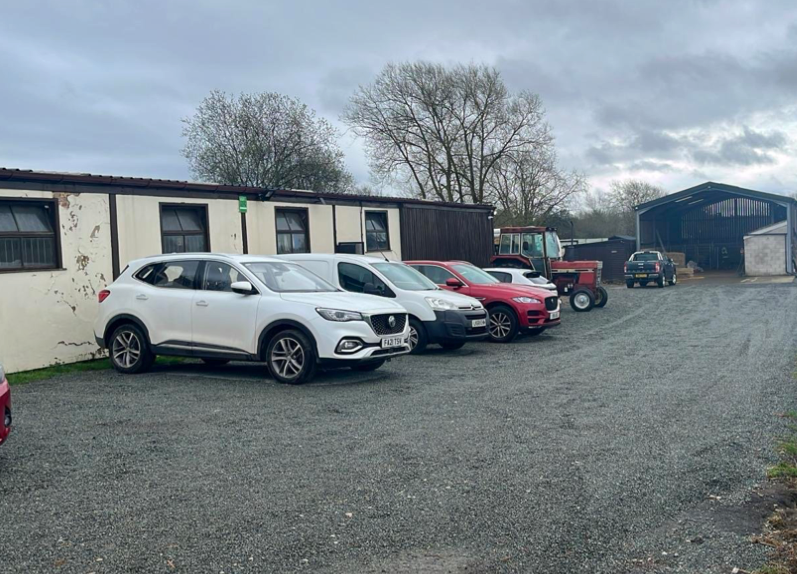 A row of cars are parked in front of a building.