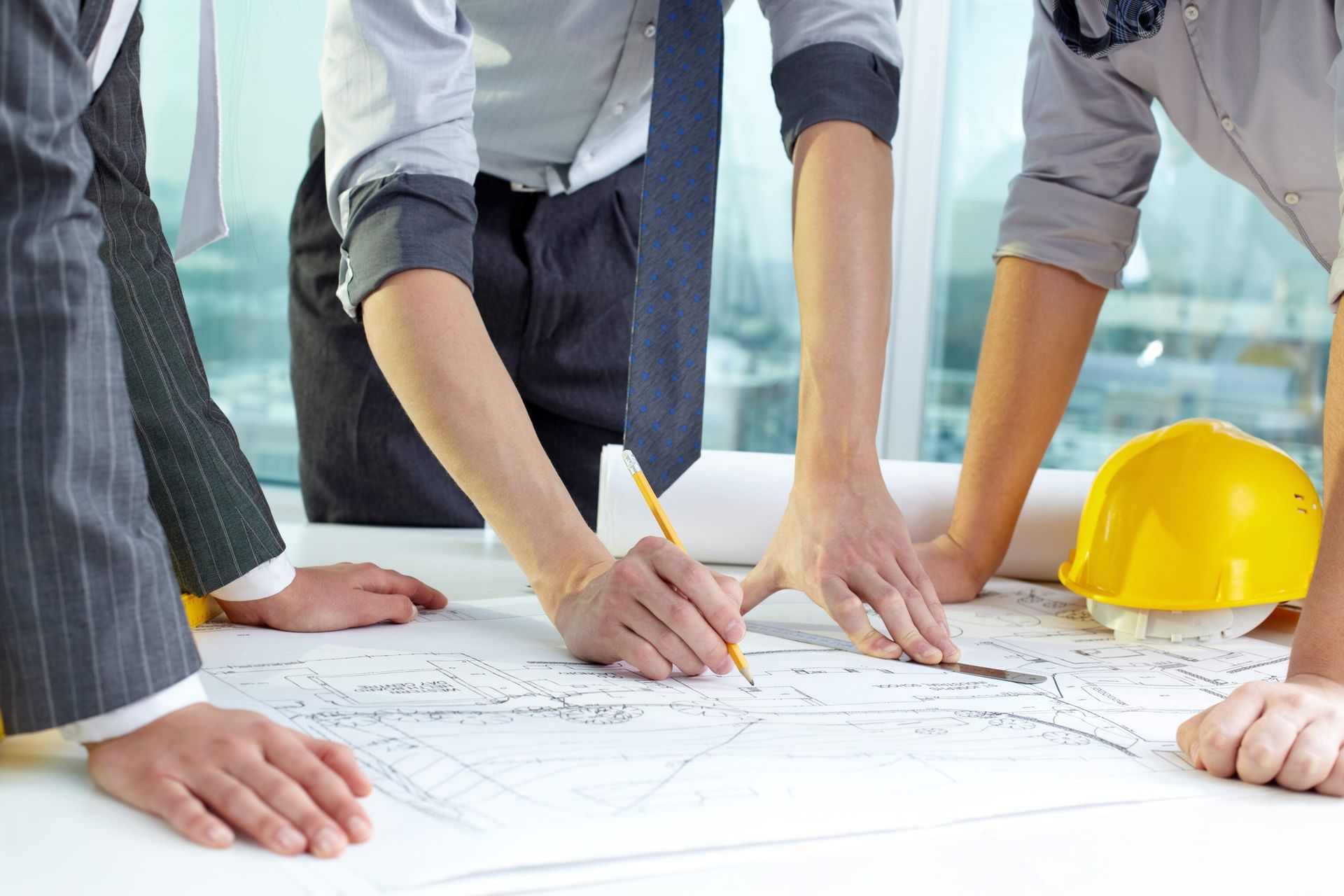 A group of people are looking at a blueprint on a table.