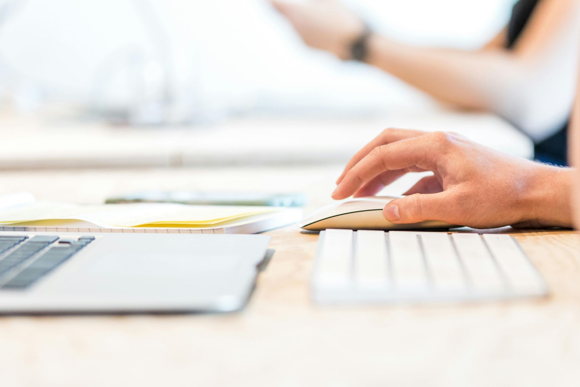 A person is typing on a computer mouse and keyboard.