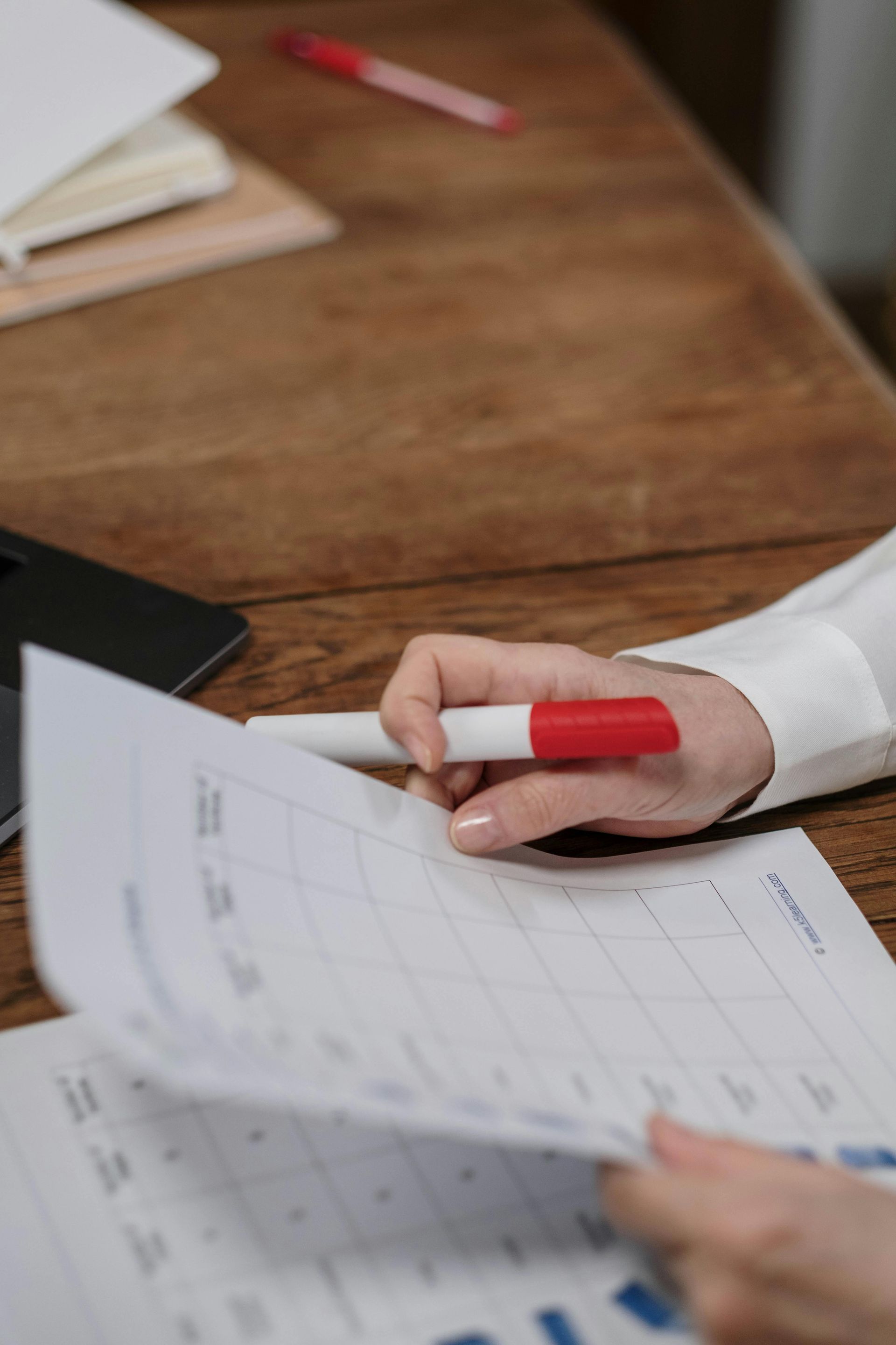 A person is holding a pen over a piece of paper.