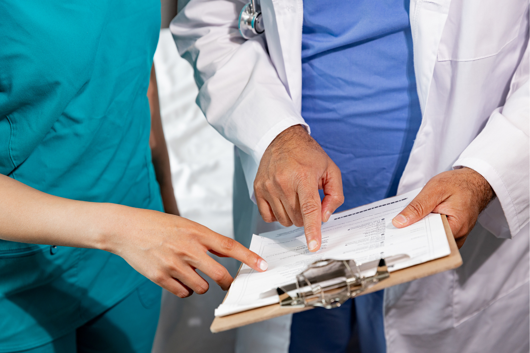 A doctor and a nurse are looking at a clipboard