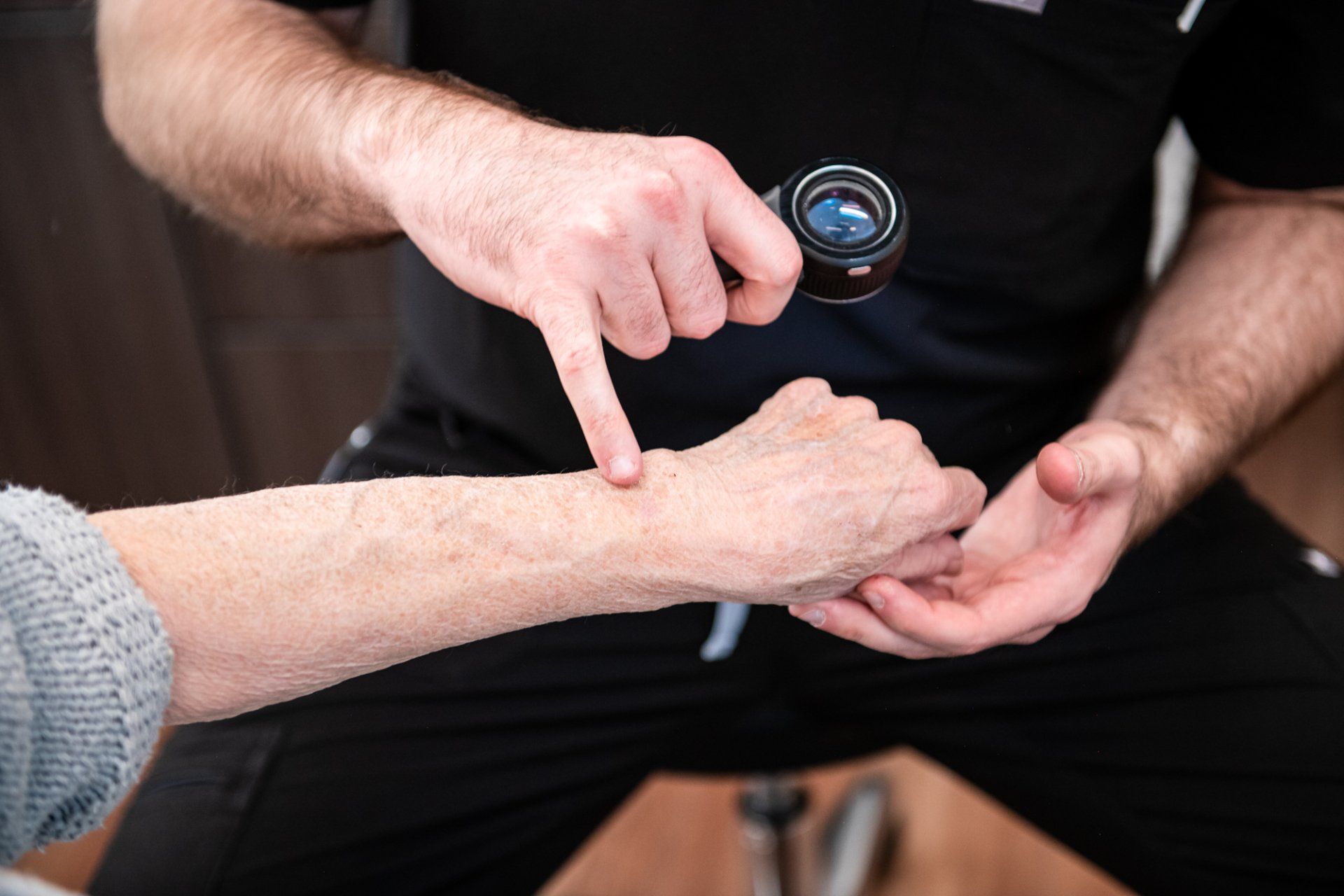 dermatologist examines a patient's hand