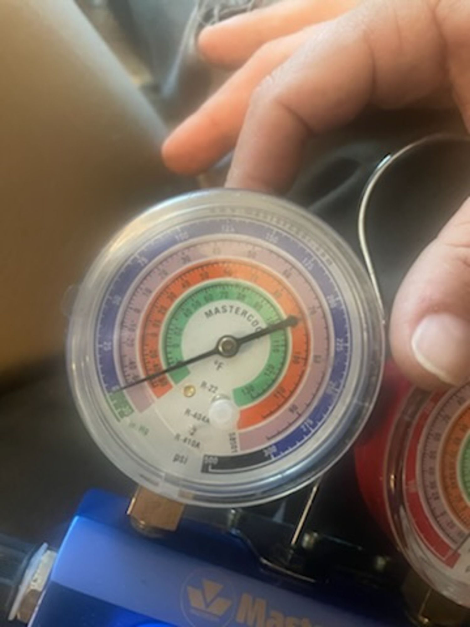 A person is holding a pressure gauge in their hand