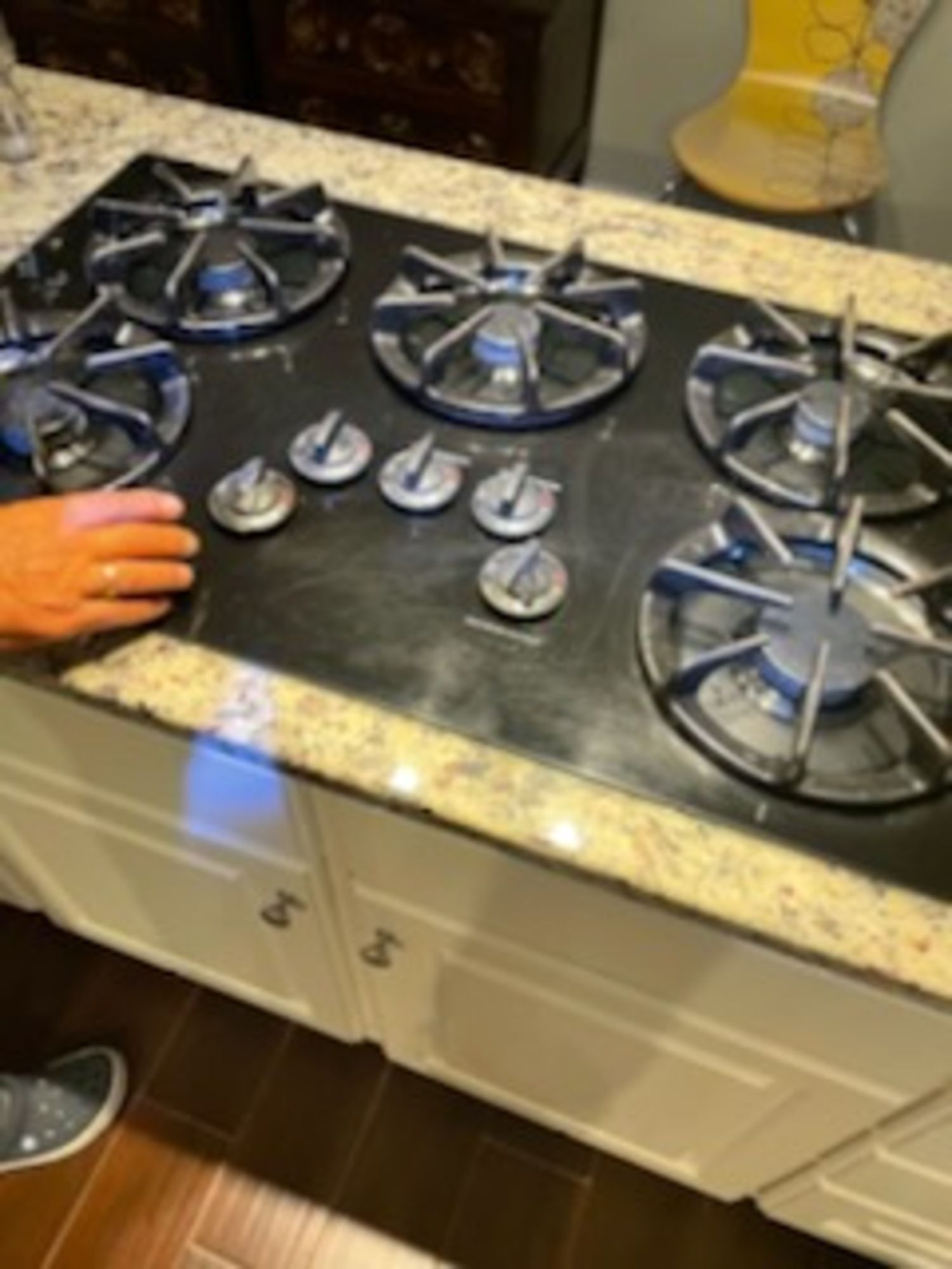 A person is touching a stove top with their hand