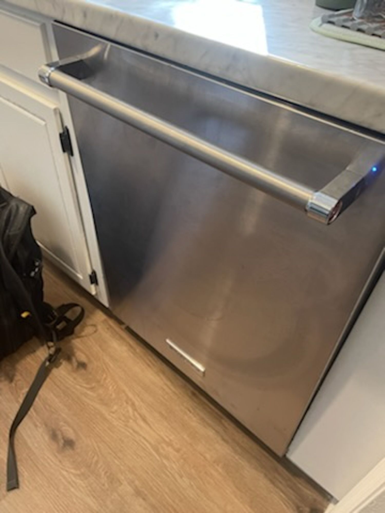 A stainless steel dishwasher is sitting under a counter in a kitchen.
