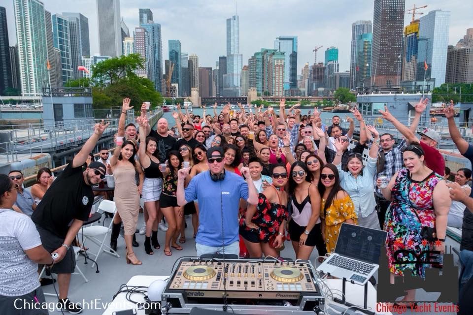 A group of people are posing for a picture in front of a dj booth.