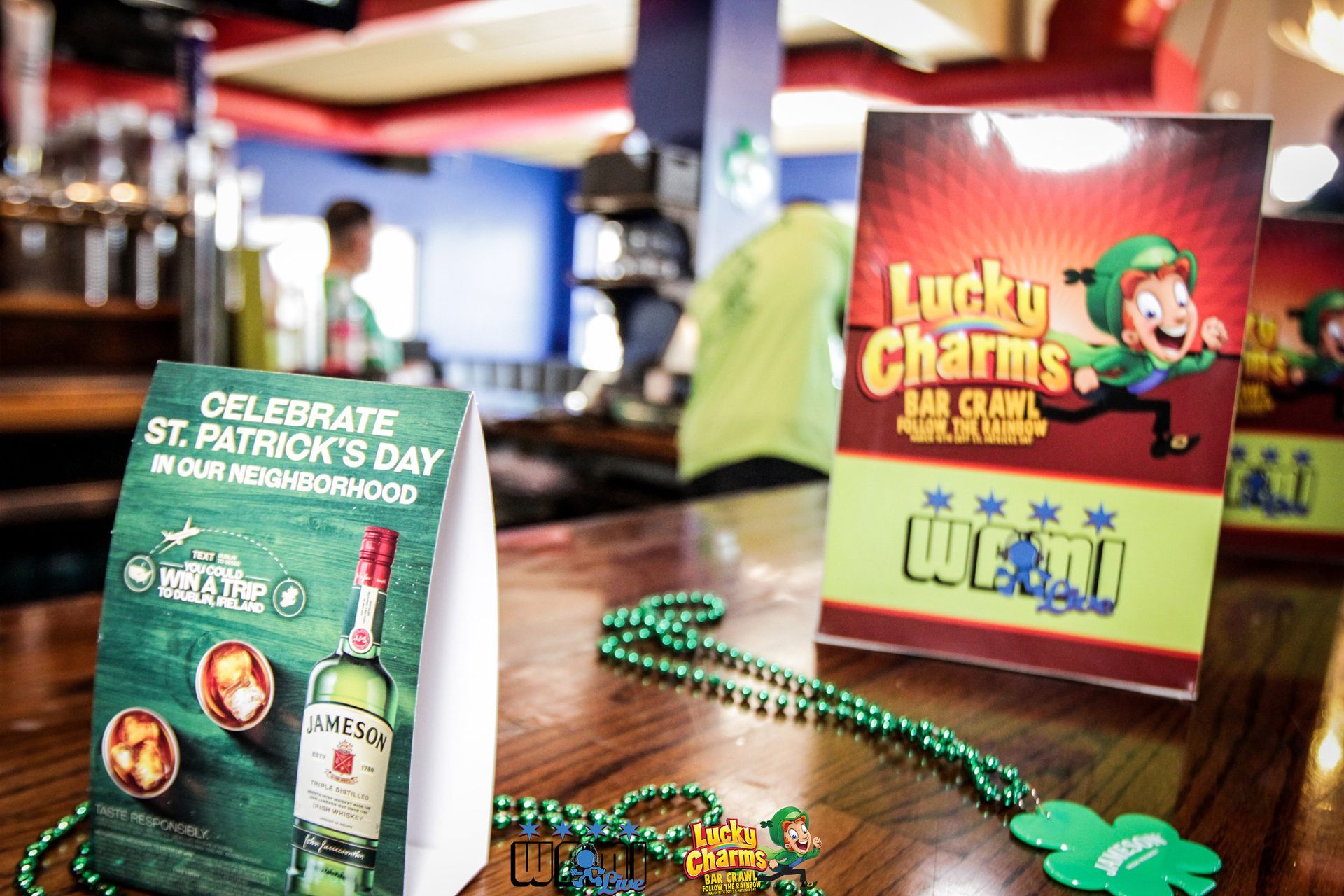 A table with a bottle of lucky charms and beads on it.