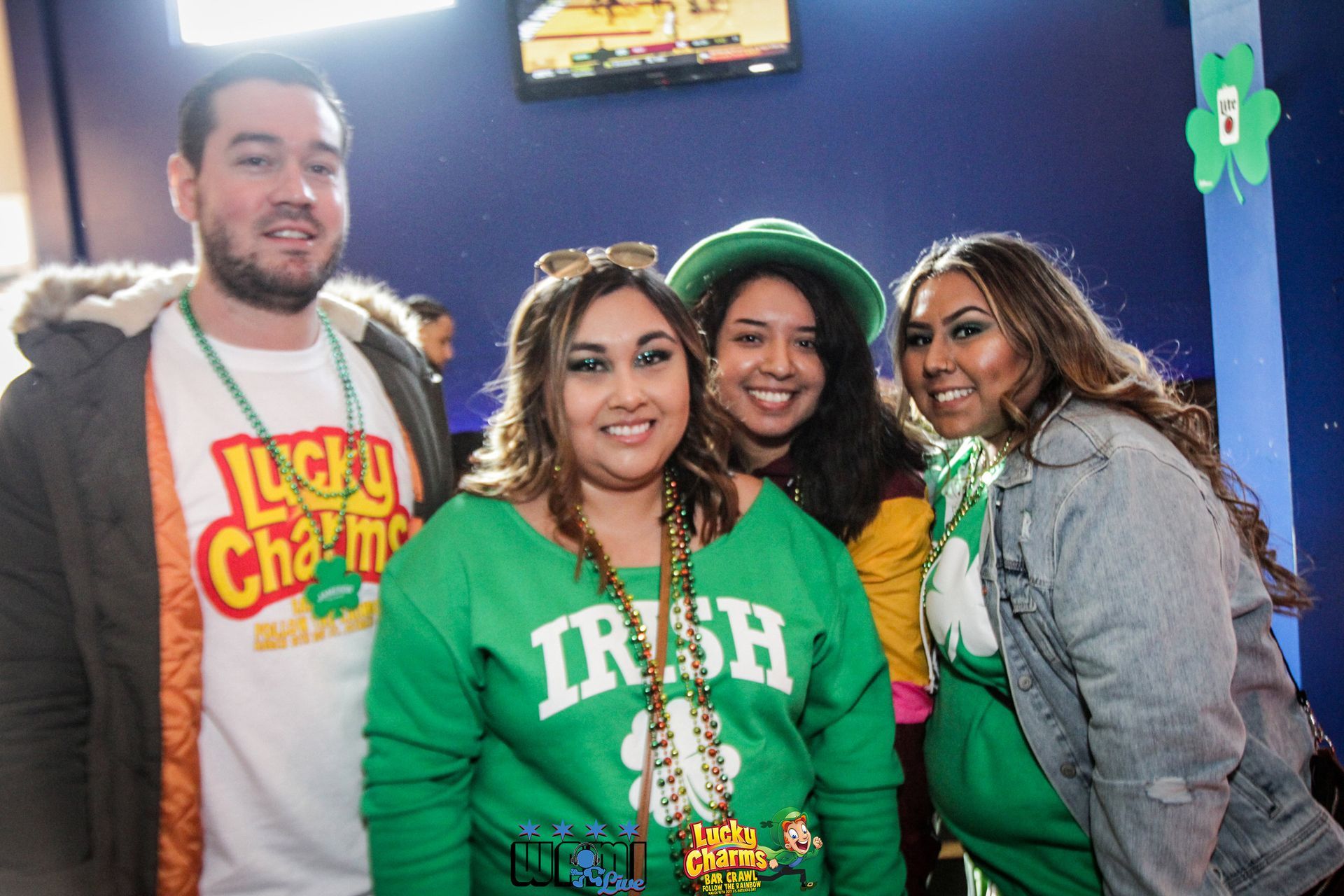 A group of people are posing for a picture and one of them is wearing an irish shirt.