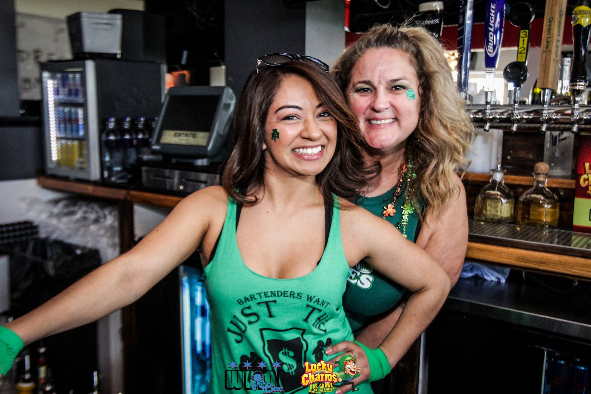 Two women are posing for a picture in front of a bar.