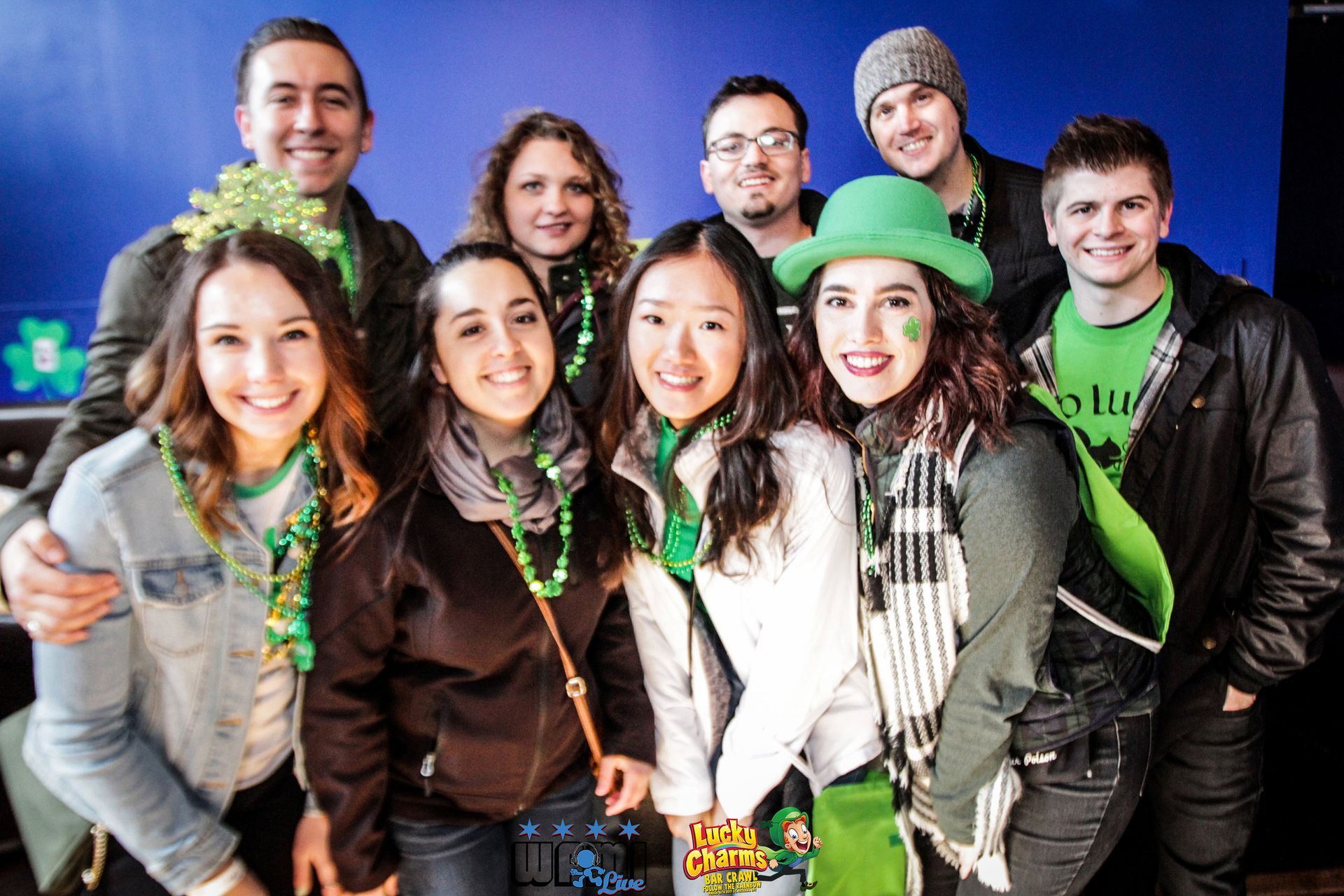 A group of people dressed in green are posing for a picture.