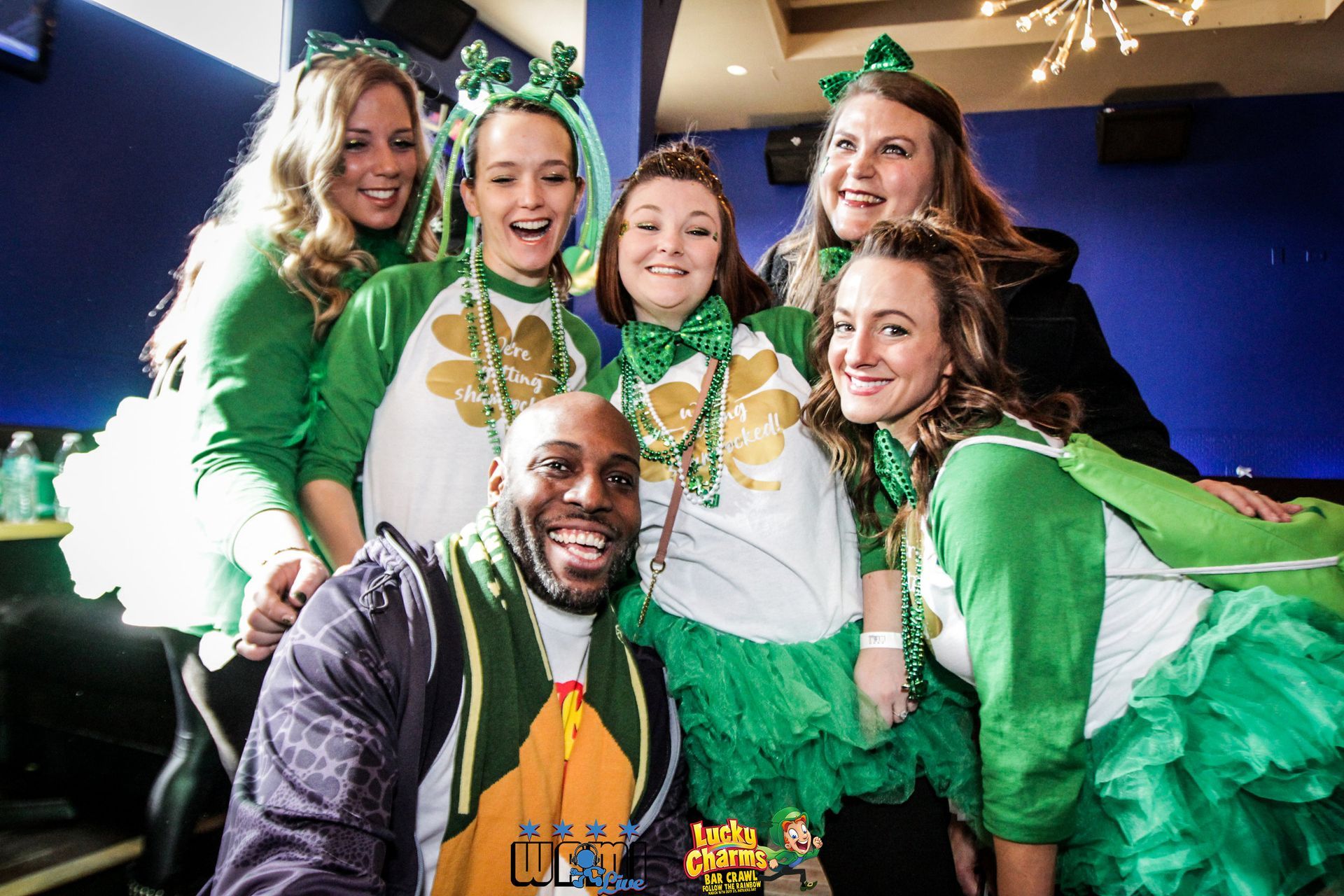 A group of people dressed in green and white are posing for a picture.