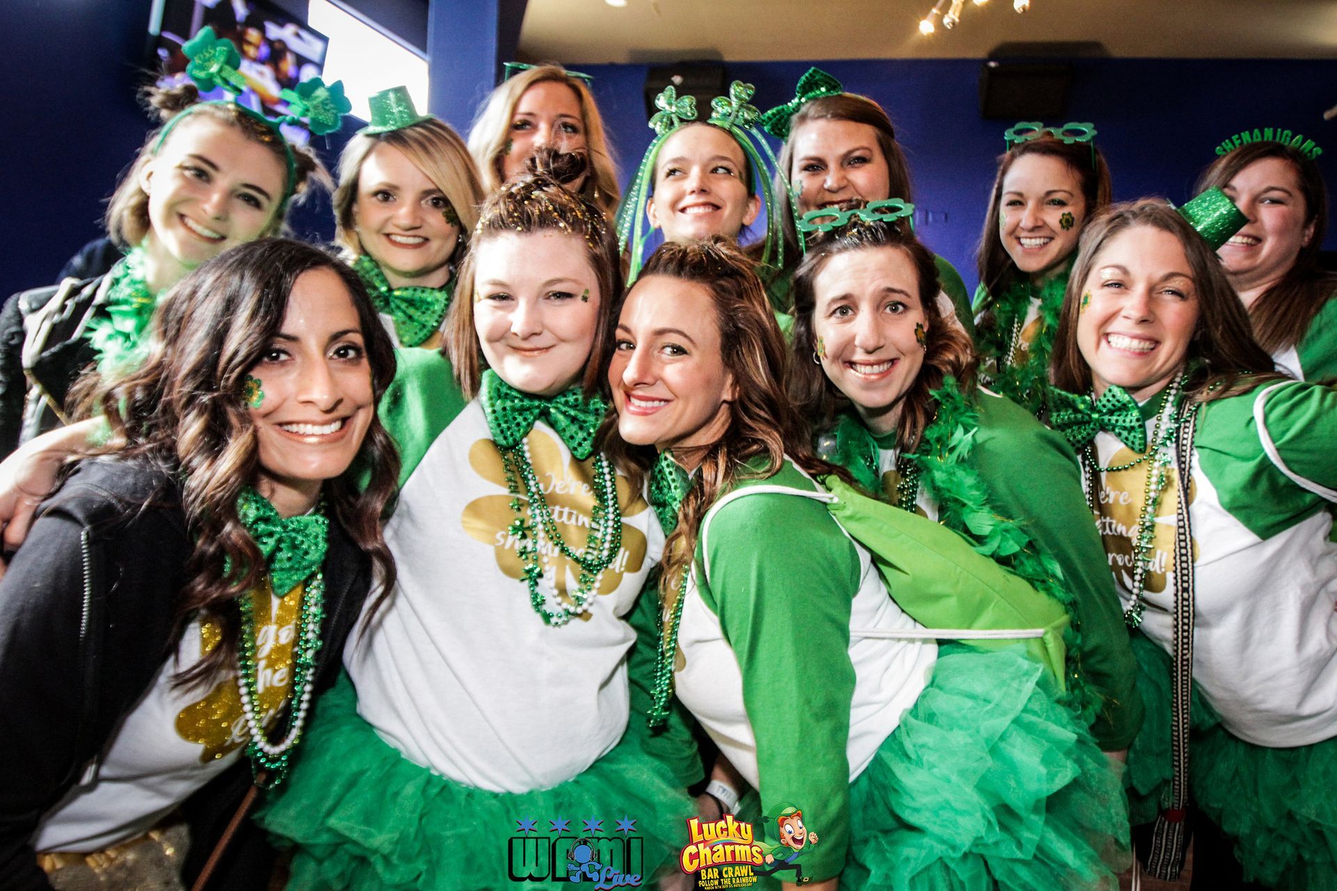 A group of women dressed in green and white are posing for a picture.