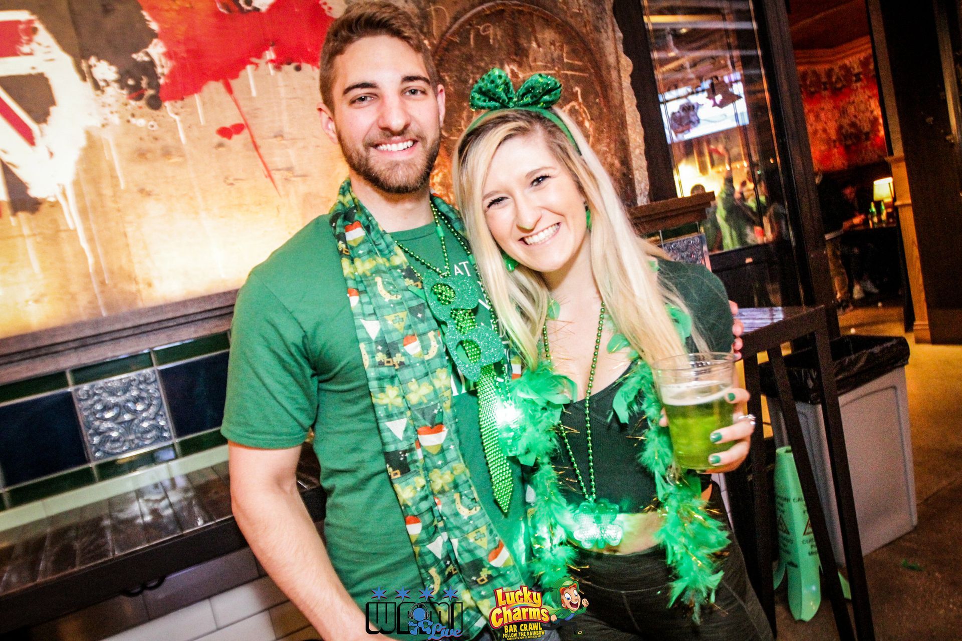 A man and a woman are posing for a picture while wearing green.