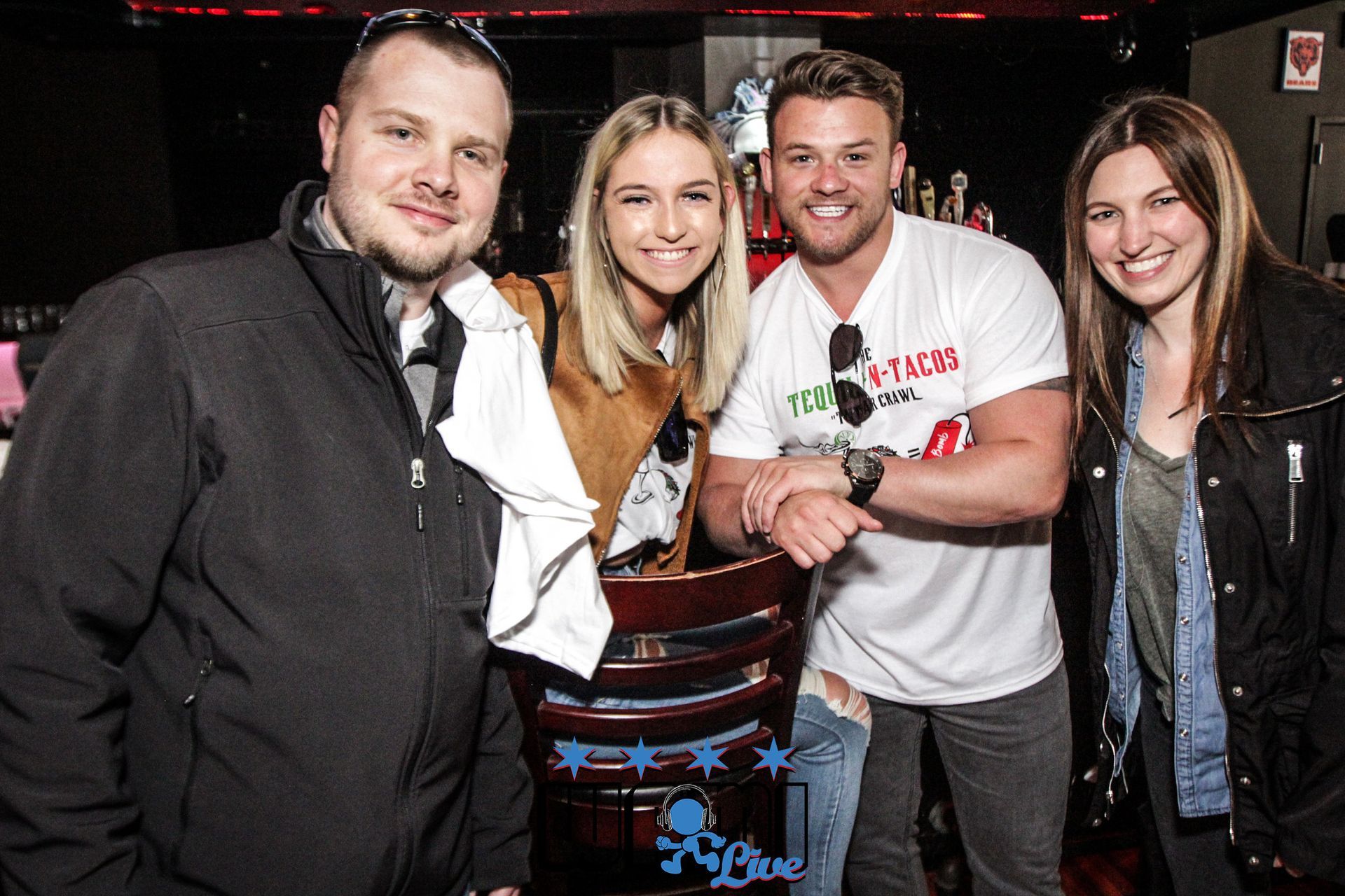 A group of people are posing for a picture in a bar.