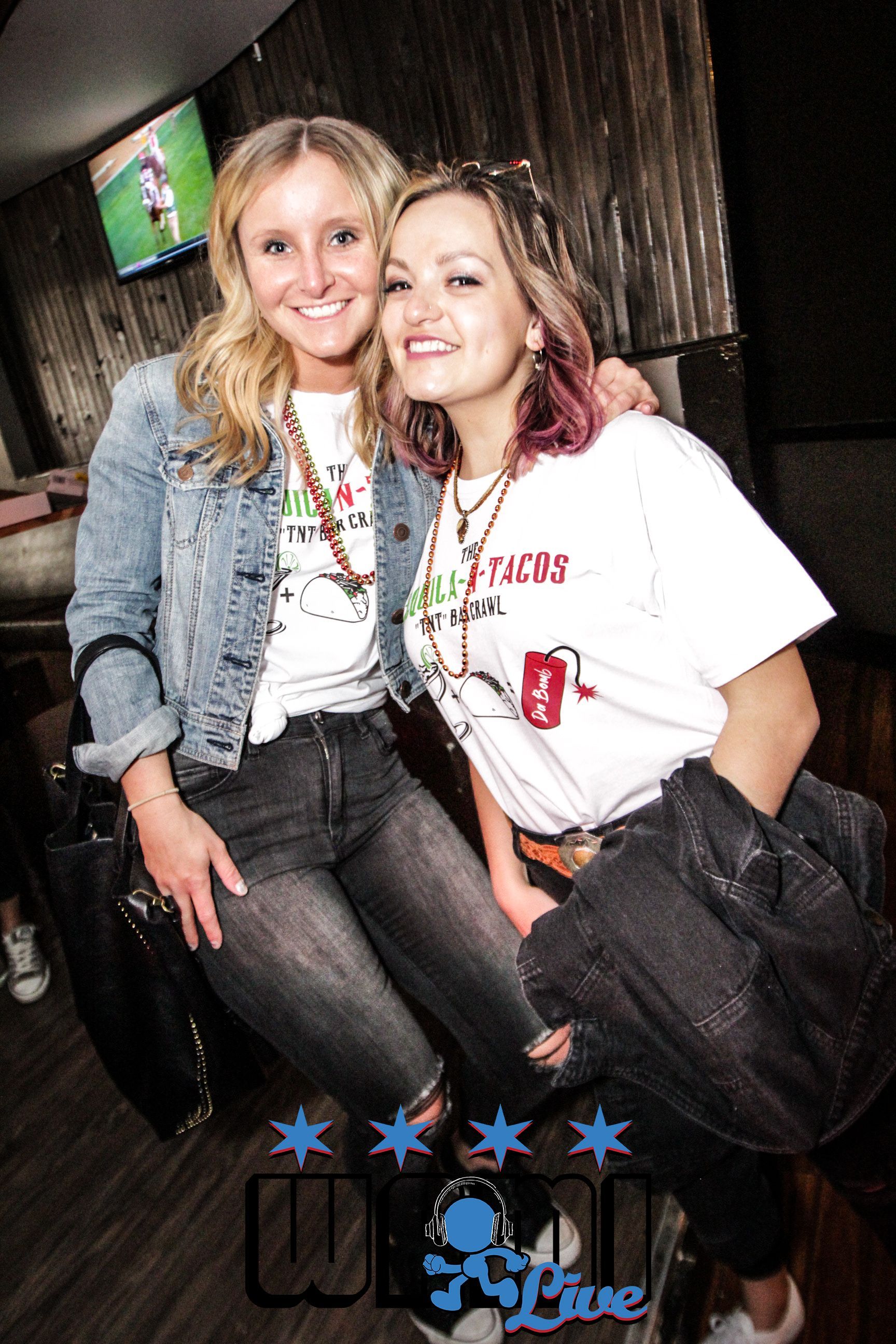 Two women are posing for a picture together in a bar.