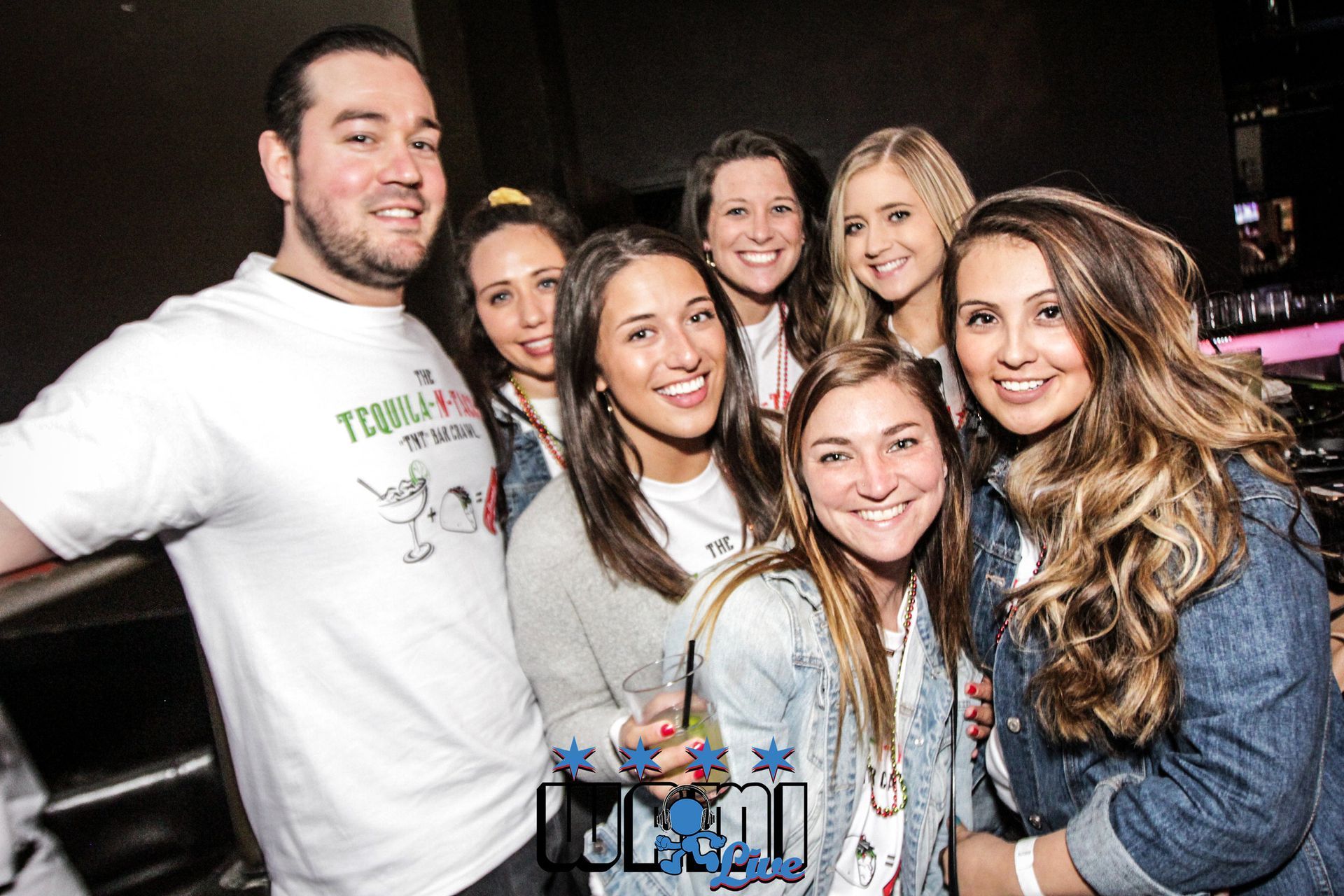 A group of people are posing for a picture in a club.