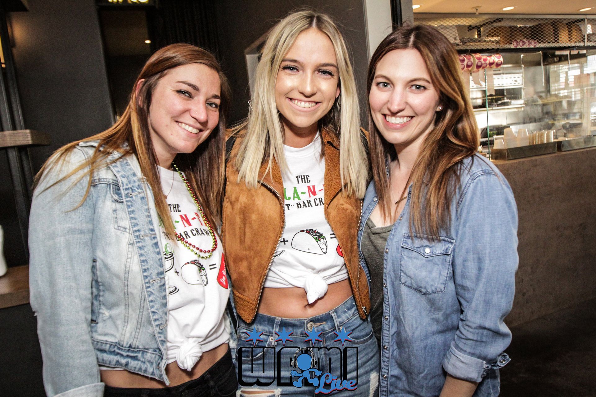 Three women are posing for a picture together and smiling for the camera.
