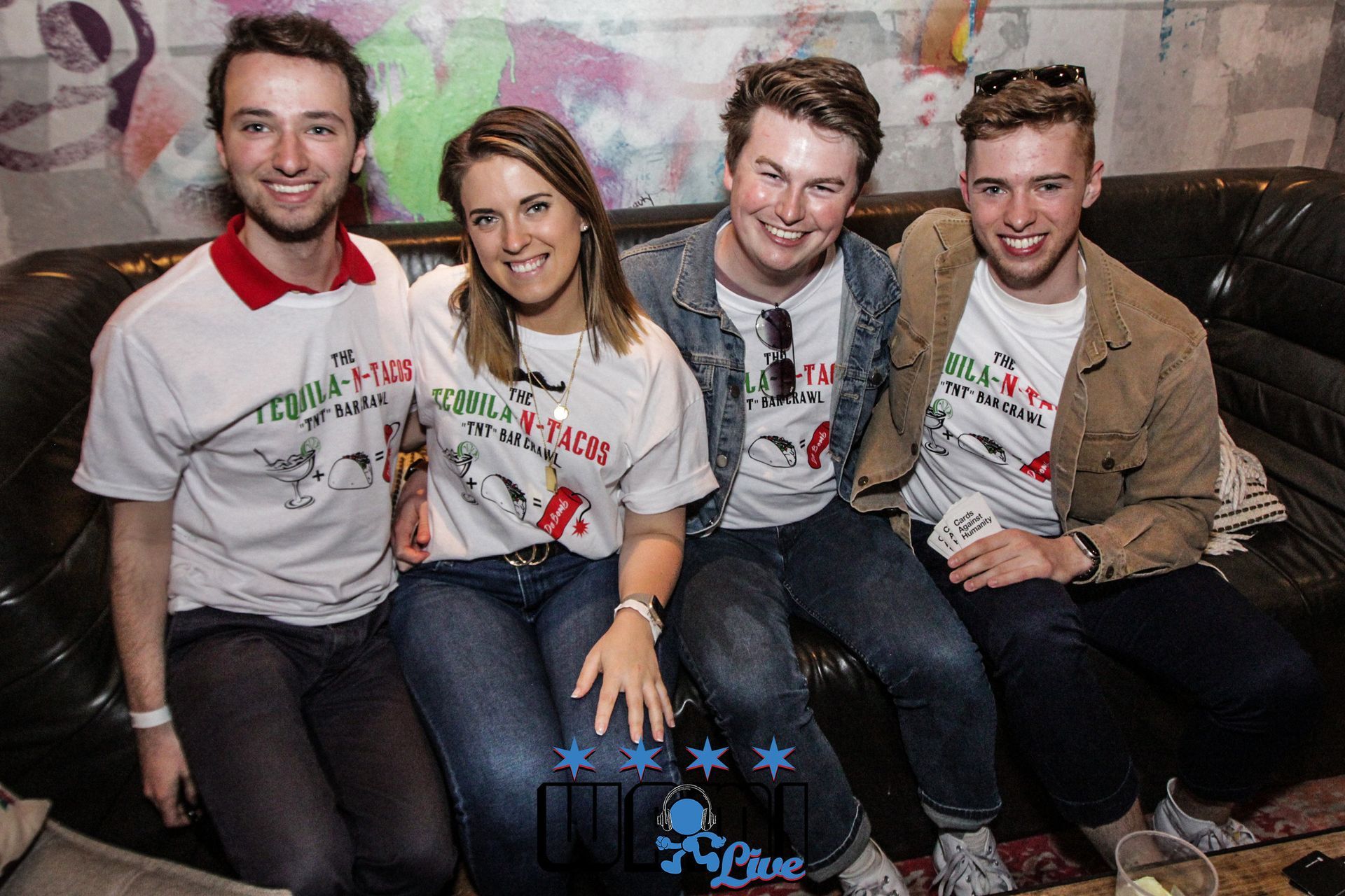 A group of people are posing for a picture while sitting on a couch.