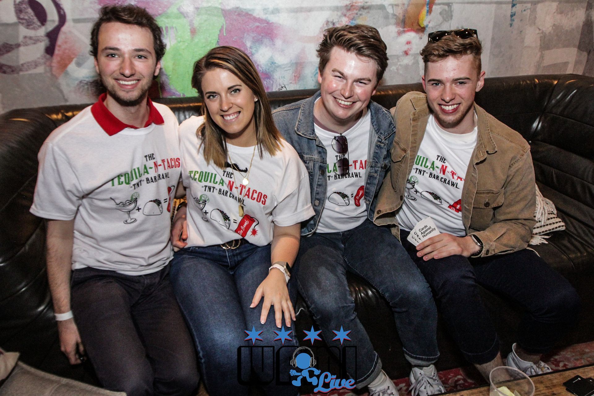 A group of people are posing for a picture while sitting on a couch.