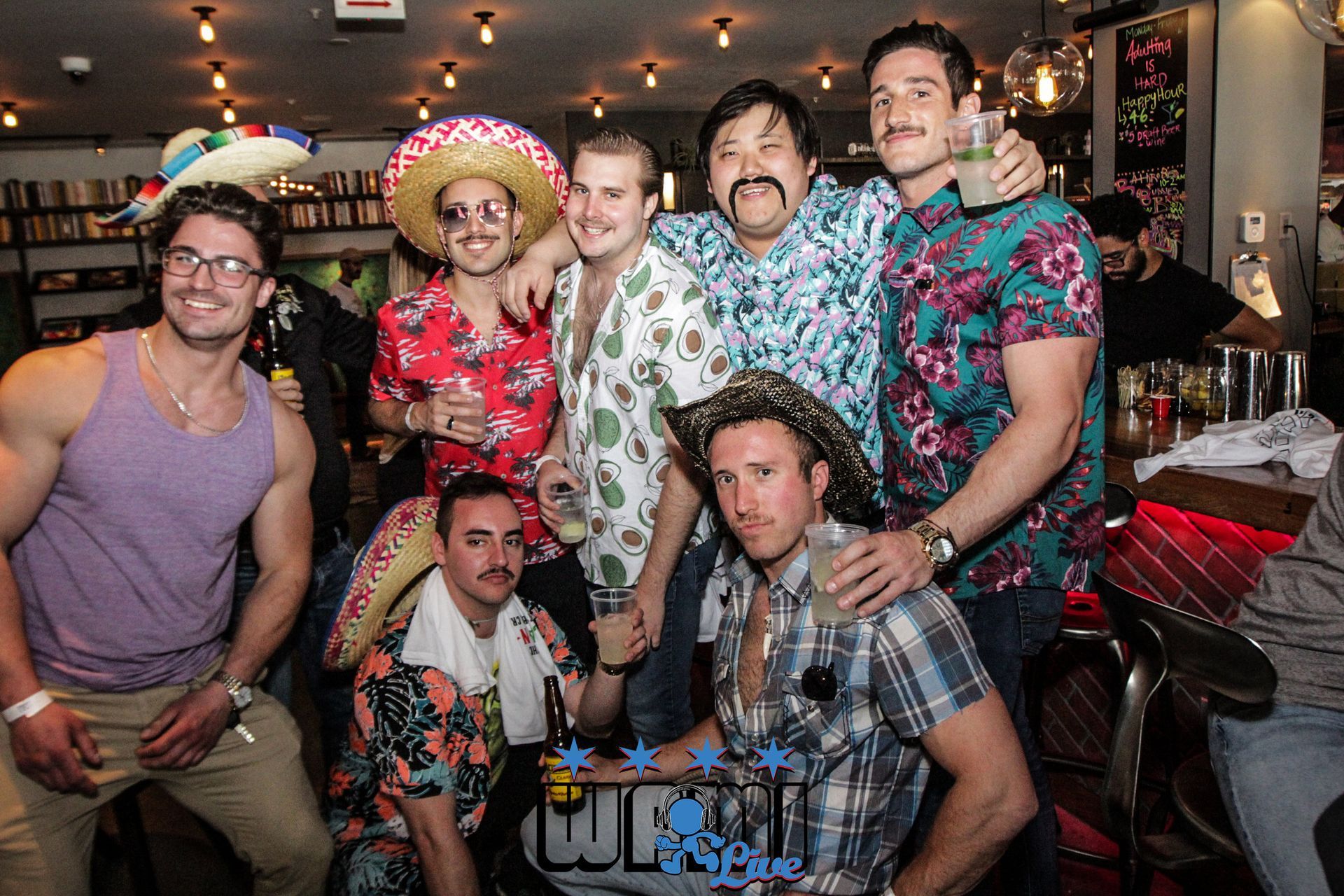 A group of men are posing for a picture in a bar.