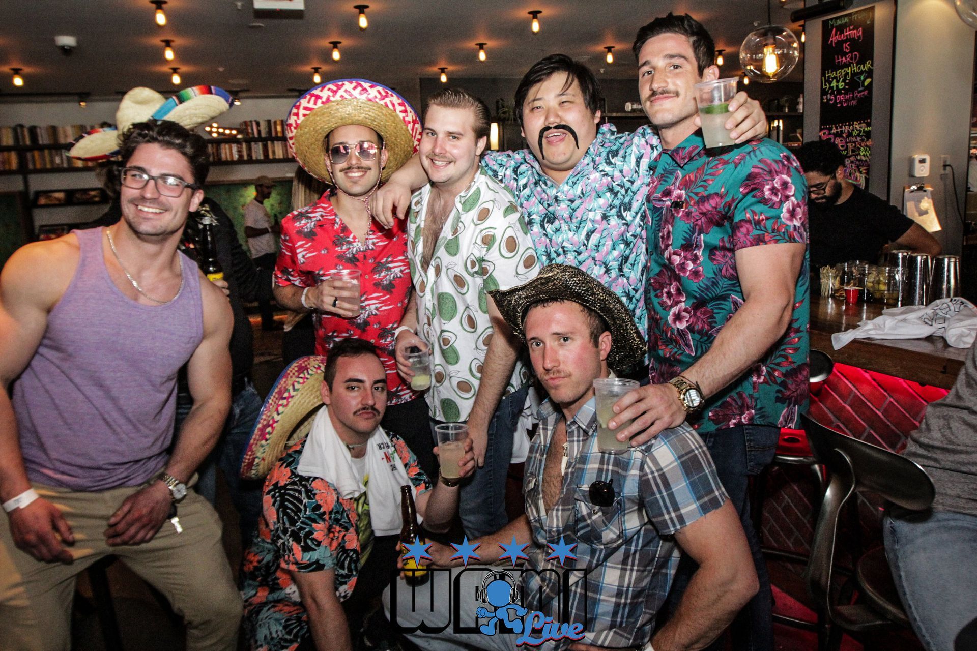 A group of men are posing for a picture in a bar.