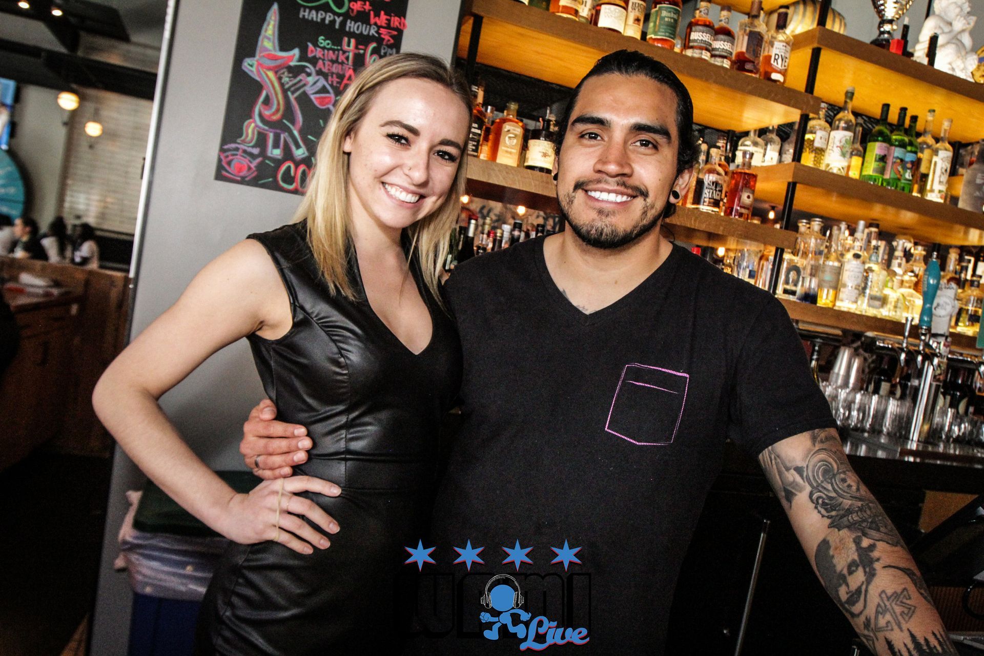 A man and a woman are posing for a picture in front of a bar.