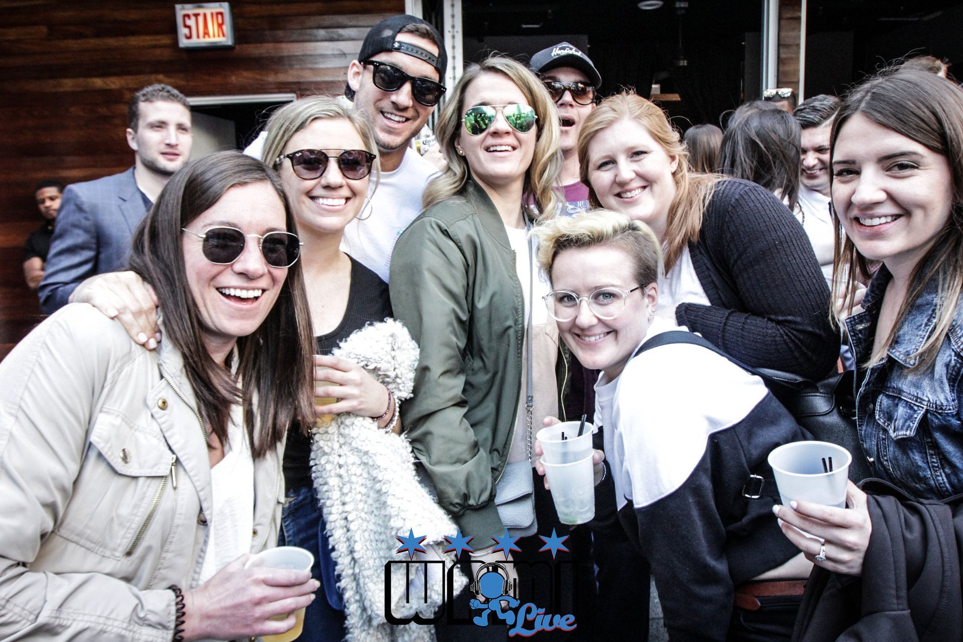 A group of people are posing for a picture while holding drinks.