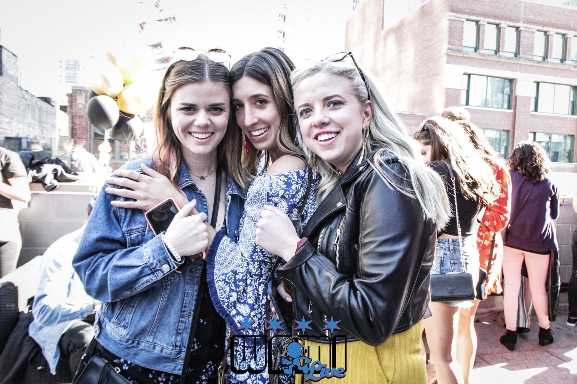 Three young women are posing for a picture in front of a building.