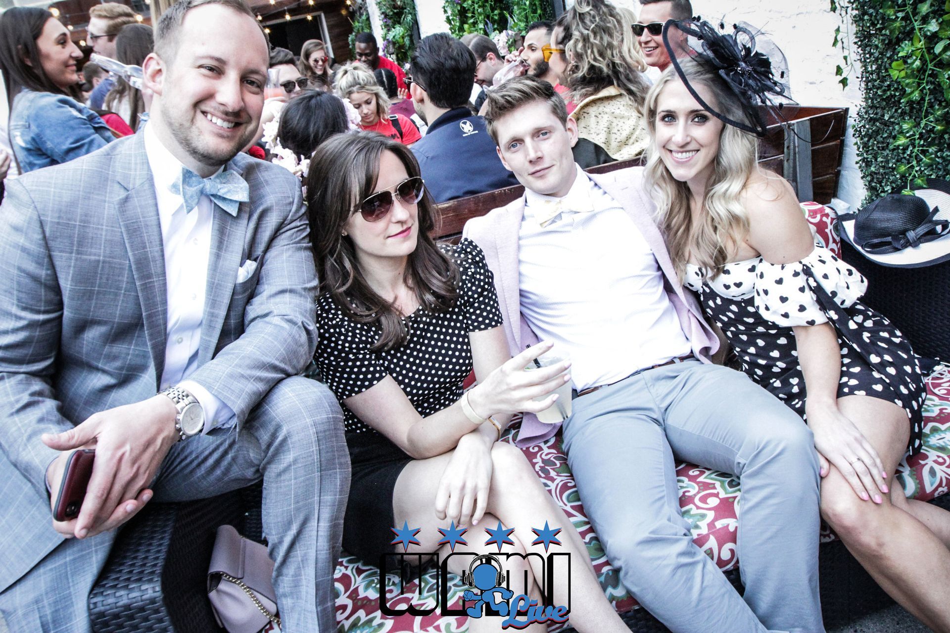 A group of people are posing for a picture while sitting on a couch.