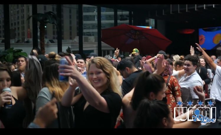 A crowd of people are gathered at a party with the word miami on the bottom