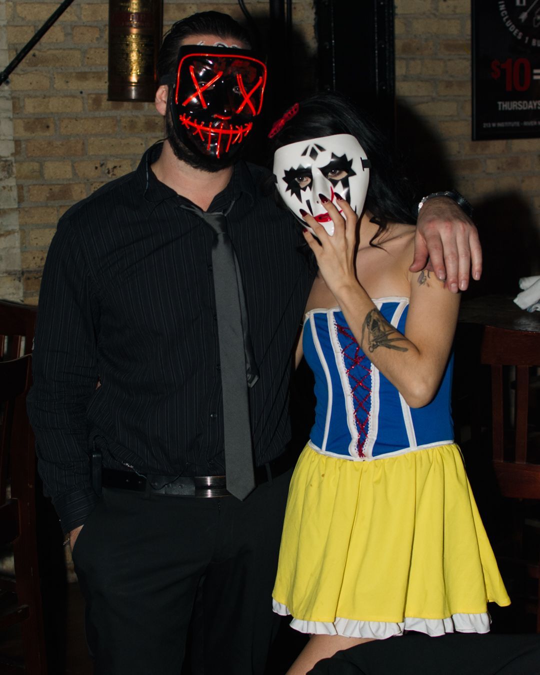 A man and a woman wearing masks pose for a picture
