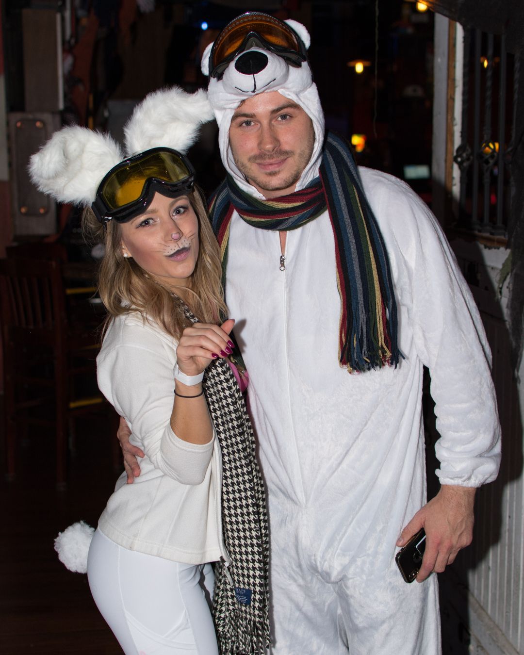 A man and a woman in polar bear costumes pose for a picture