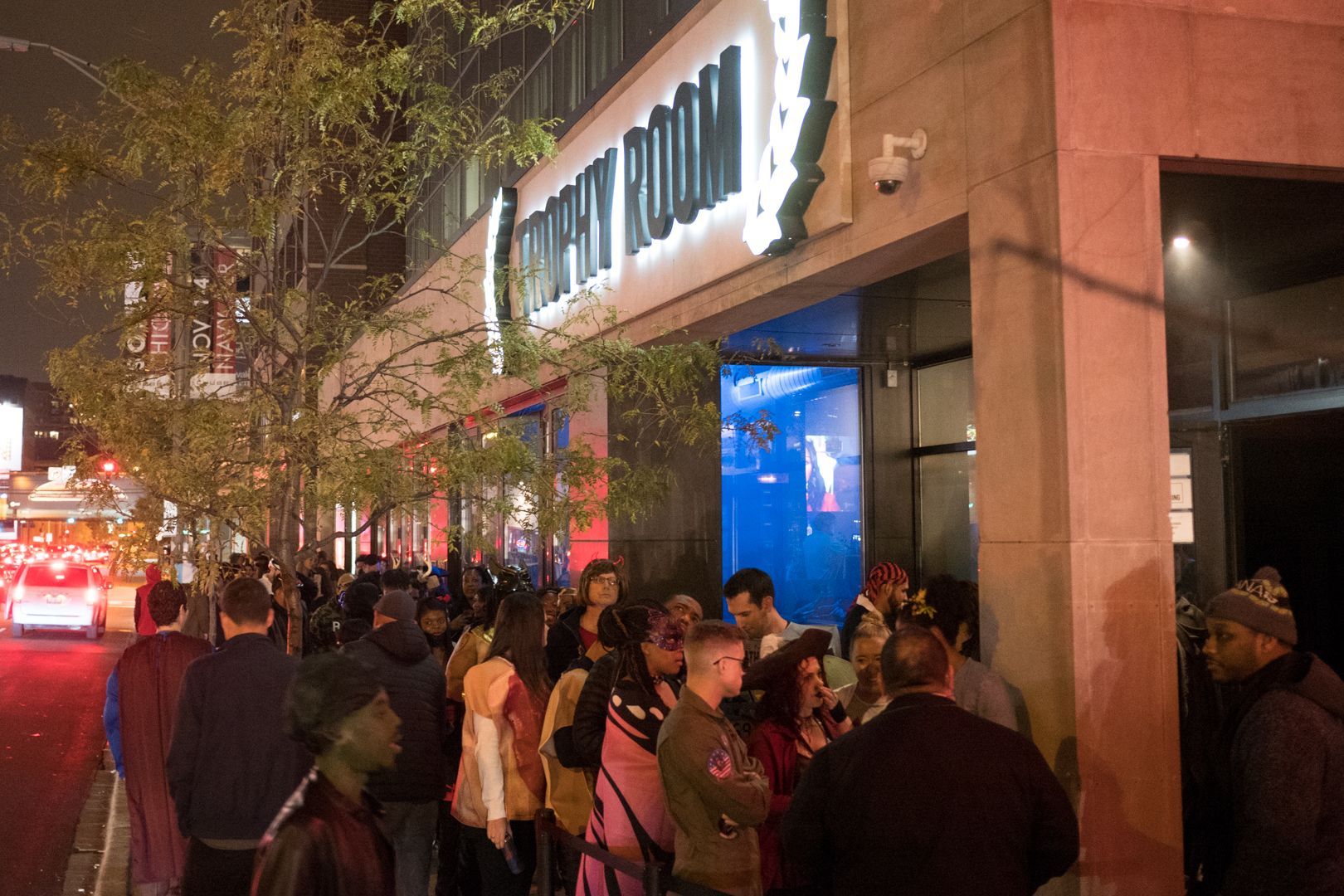 A group of people standing outside of a building that says company room