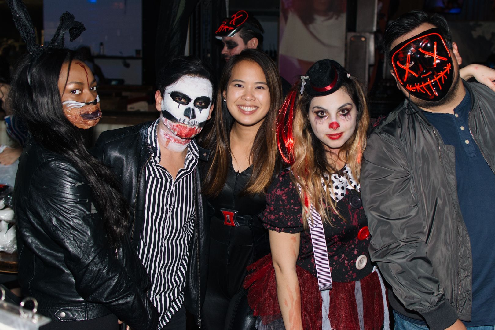 A group of people dressed in halloween costumes are posing for a picture.