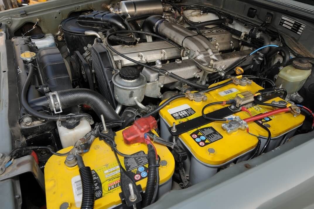 A car engine with two yellow batteries in it