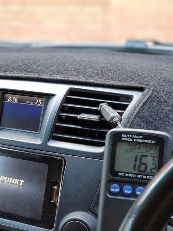 A car dashboard with a thermometer and a radio