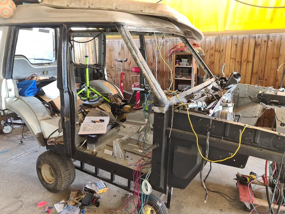 A golf cart is being built in a garage.