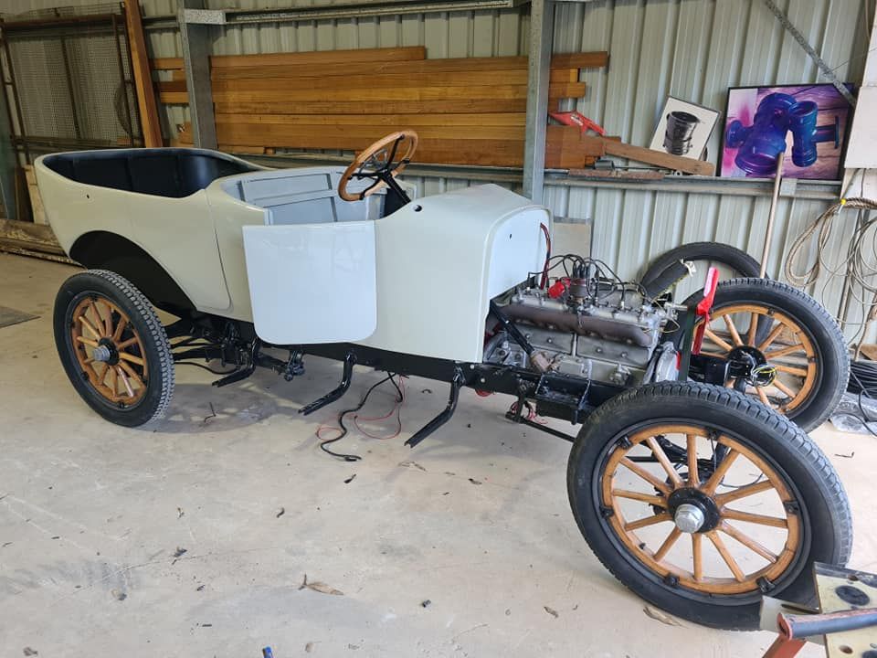 An old car is being restored in a garage.