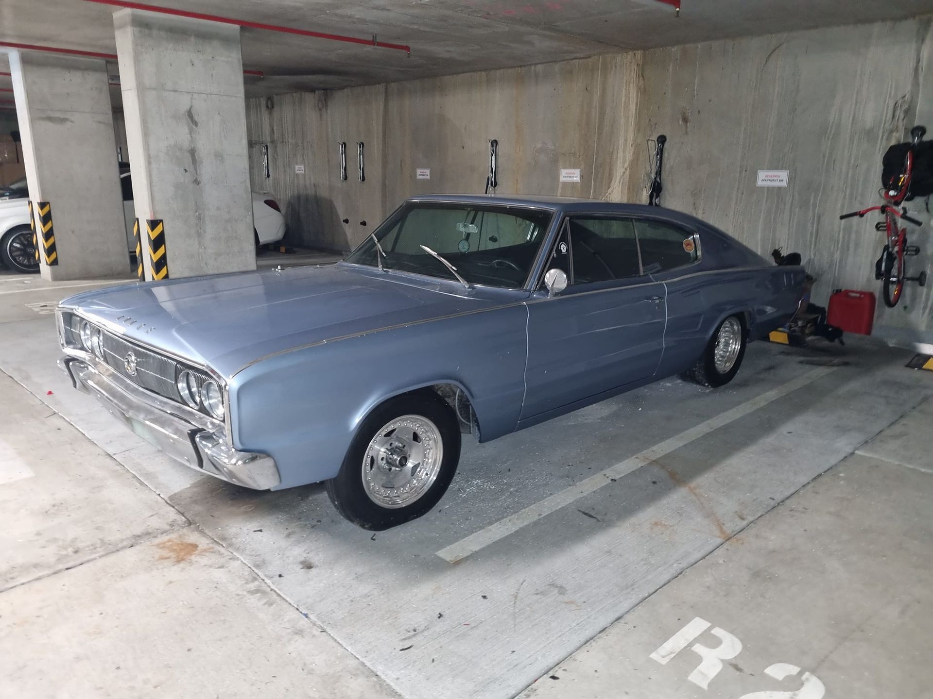 A blue car is parked in a parking garage.