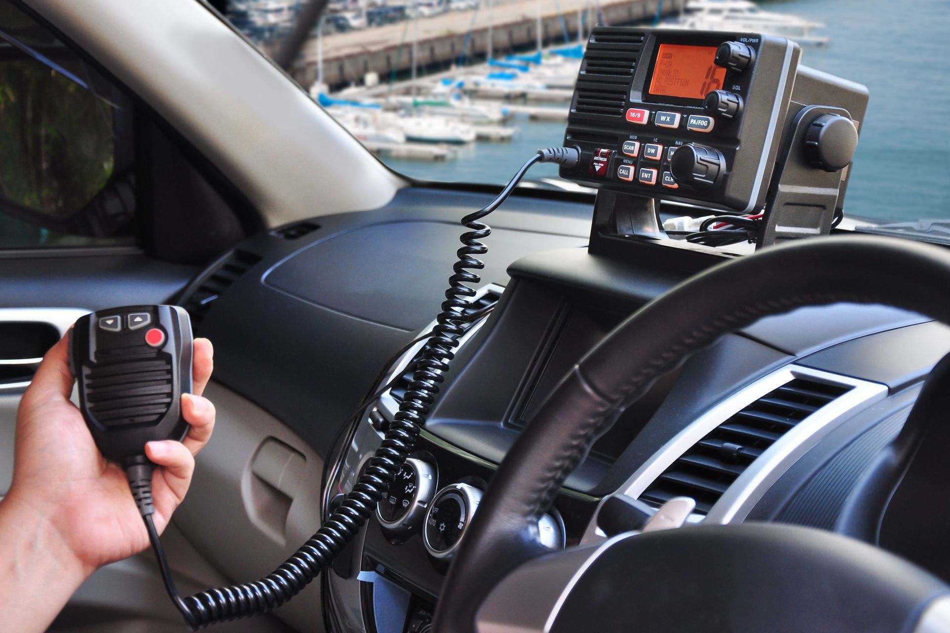 A person is holding a walkie talkie in a car