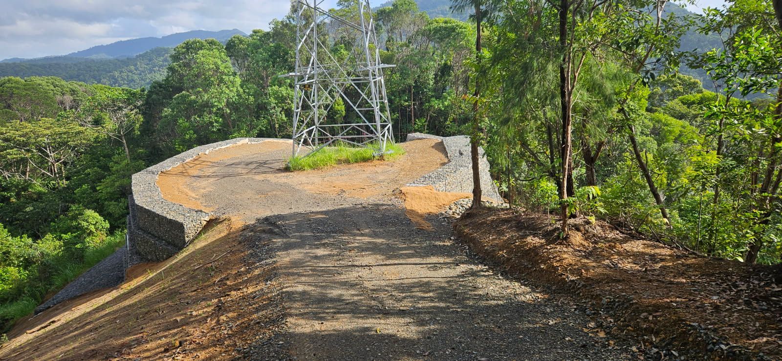 A Gravel Road Leads to a Clearing With a Utility Tower — STJ Earthmoving in Mareeba, QLD