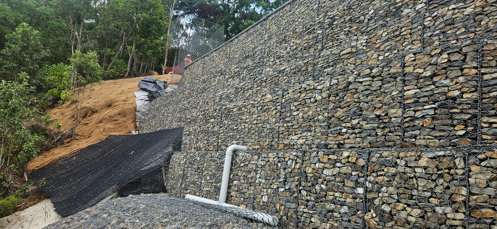 A Hillside Retaining Wall Made of Wire Mesh Baskets Filled — STJ Earthmoving in Mareeba, QLD
