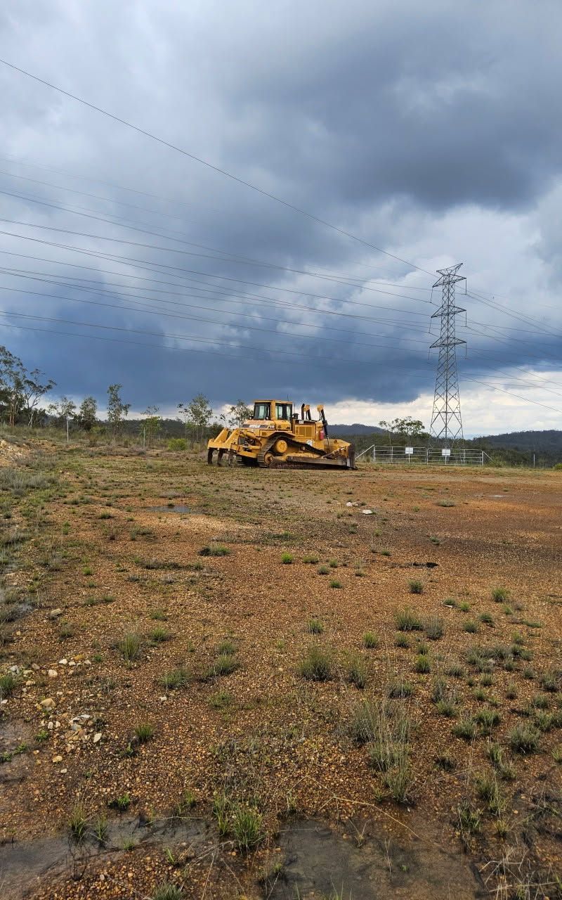 Yellow Bulldozer in a Barren Field Under a Cloudy Sky — STJ Earthmoving in Mareeba, QLD