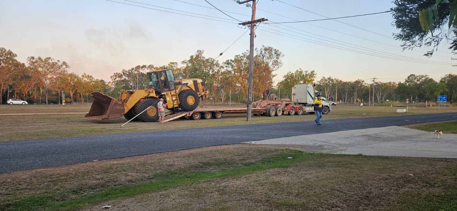 A Yellow Bulldozer is Being Transported on a Flatbed Trailer — STJ Earthmoving in Mareeba, QLD