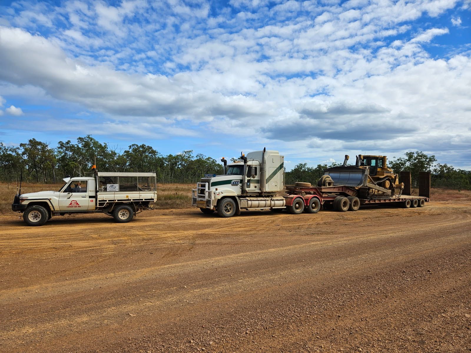 White Truck Towing a Bulldozer on a Trailer — STJ Earthmoving in Mareeba, QLD