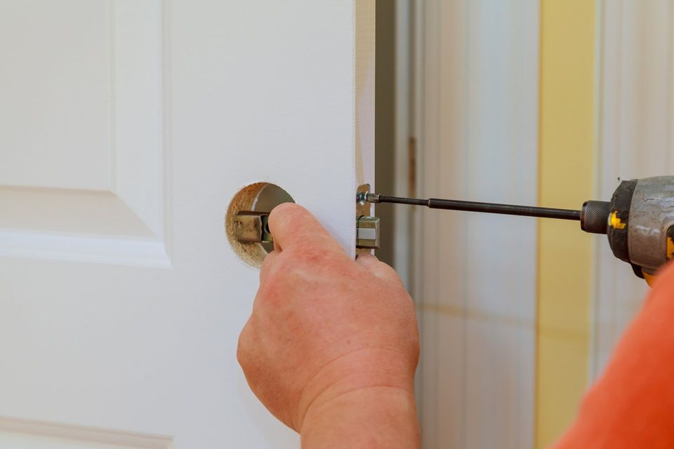 Locksmith — Hands Changing Doorknob Of A Door in Philadelphia, PA