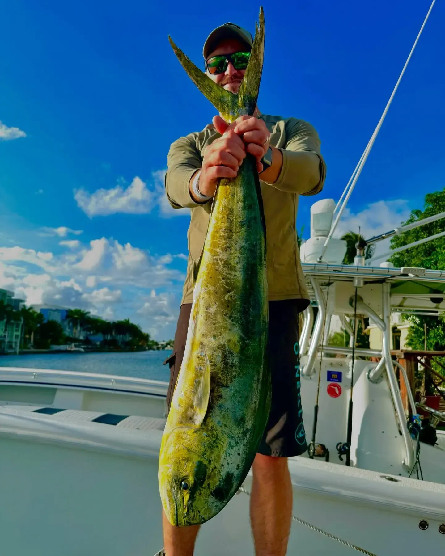 A man is holding a large fish on a boat.